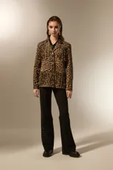 Blazer de poliéster con estampado animal print de leopardo, diseño holgado, cuello solapa, cierre frontal con botones y flecos decorativos en el pecho y la espalda. Incluye bolsillos frontales.