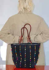 Cartera tipo tote de gamuza color marrón, con correas trenzadas y detalle de piedras naturales incrustadas en líneas verticales. Cuenta con cierre metálico y forro interior de tela.