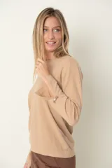 Buzo marrón de punto con cuello redondo y mangas largas. Detalle de puño abierto con moña y perla.