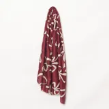 Pashmina de textura suave con estampado geométrico de formas abstractas en color bordó y beige.