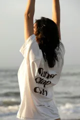 Remera oversize blanca con estampado en la espalda que dice "Sunset Clap Club uruguayan members only".