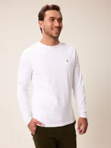 Remera de manga larga en color blanco, con cuello redondo y pequeño logo bordado en el pecho.