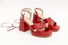 Sandalias color beige con plataforma y tacón cuadrado. Presentan tiras cruzadas en el empeine y tiras largas para atar alrededor del tobillo.