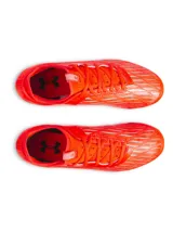 Championes de fútbol Under Armour Magnetico Select 4 FG, color naranja vibrante con detalles en gris claro y verde lima. Presentan una parte superior de piel sintética con estampado 3D para mayor control, cuello textil tipo calcetín y suela de TPU con tacos cónicos.