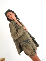 Blazer de jean 100% algodón con denim ahumado, bolsillos tipo cargo y detalles de estribos en bronce.