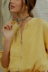 Campera tipo bomber de lino color amarillo, con cierre frontal metálico y mangas largas con puños elásticos.