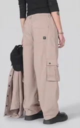 Pantalón cargo de corte oversize y silueta estructurada, color beige. Confeccionado en microfibra pesada, cuenta con cintura elástica con cordón de ajuste, cierre frontal con botón, bolsillos laterales y bolsillos cargo de gran tamaño con tapa y broches a presión.