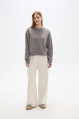 Pantalon de corte amplio y tiro alto, confeccionado en poliester, con bolsillos laterales tipo cargo.