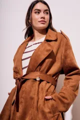 Trench marrón de gamuza vegana con cuello solapa, manga larga, cinturón con hebilla y corte evasé.