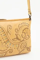 Cartera bandolera de cuero vacuno color verde bosque, con diseño floral bordado y tachas metálicas en tonos dorados y plateados envejecidos. Posee correa regulable y cierre superior.