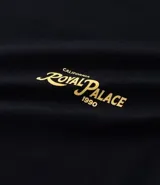 Remera masculina negra de algodón, corte comfort, con cuello redondo y mangas cortas. Presenta una estampa lettering con follaje "Royal Palace" en amarillo en el frente y la espalda.