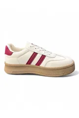 Championes deportivos de plataforma color beige con dos rayas negras laterales, suela de goma marrón y detalles en azul oscuro en el talón.