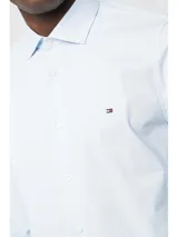 Camisa Tommy Hilfiger de algodón Oxford celeste con microestampado. Tiene corte regular, cuello abotonado, mangas largas con puños abotonados y logo bordado en el pecho.