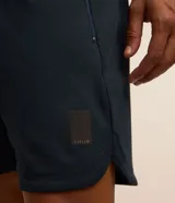 Bermuda deportiva masculina de color azul marino, con cintura elástica y cordón ajustable, bolsillos laterales con cierre y tecnología Dry para mayor transpirabilidad.