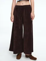 Pantalon de corte amplio y silueta relajada, confeccionado en pana negra. Presenta cintura elástica y bolsillos laterales.