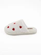 Pantuflas de peluche color blanco con estampado de corazones rojos, diseño abierto y suela plana.