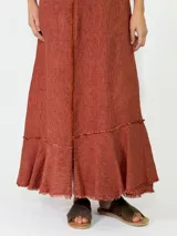 Vestido largo sin mangas de lino azul, con escote en V, bolsillos laterales y detalles de costuras marrones a la vista con terminaciones deshilachadas en el bajo.