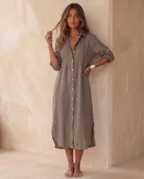 Vestido camisero midi verde militar, confeccionado en lino, con cuello camisero, botonadura frontal completa con botones de nácar, mangas 3/4 con presilla y dobladillo redondeado con aberturas laterales.
