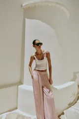 Pantalón fluido de tiro alto con cintura elástica y pernera ancha, de color rosado.
