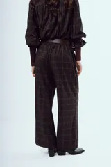 Pantalon de vestir tiro alto corte ancho confeccionado en tela a cuadros.
