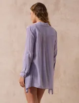 Camisa larga de rayón, con cuello clásico, cierre frontal con botones y mangas regulables con presilla. Presenta un diseño holgado con tajos laterales en el ruedo.
