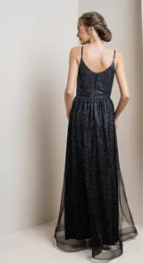 Vestido largo de fiesta con escote en V cruzado y tirantes finos. Confeccionado en tela negra con acabado de glitter brillante, presenta un corte entallado en la cintura y falda con caída fluida.