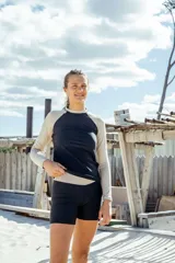 Conjunto de remera manga larga con protección UV, color negro con mangas color beige, y calza corta color negro.