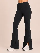 Conjunto deportivo compuesto por un top básico sin mangas de cuello redondo y una calza acampanada de tiro alto con aberturas laterales en el ruedo. Ambas piezas son de color negro y presentan un diseño minimalista.