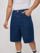 Bermuda de jean azul oscuro, 100% algodón, con corte holgado y bolsillos laterales.