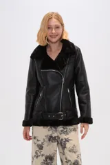 Chaqueta negra de cuero sintético con interior de piel sintética, corte al cuerpo, cierre frontal asimétrico con cremallera, cuello solapa con hebillas y cinturón con hebilla en la cintura.