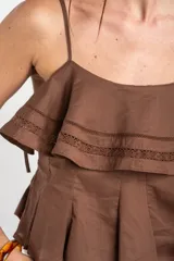 Top negro de 100% algodón, con tirantes finos, escote recto y volados dobles con detalles de encaje en el frente.