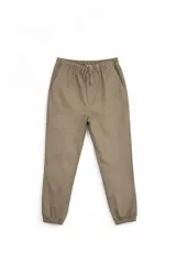Pantalón tipo jogger color beige, con cintura elástica ajustable mediante cordón y puños elásticos en los tobillos.