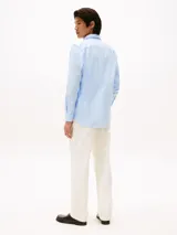 Camisa celeste de corte slim fit, confeccionada en tejido dobby de algodón con tecnología Flex. Presenta cuello abotonado, manga larga y logo de Tommy Hilfiger bordado en el pecho.