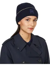 Gorro de lana azul marino con punto canalé y vuelta. Presenta un ribete dorado en el borde inferior y el monograma TH bordado en el frente.