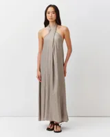 Vestido largo color dorado metalizado, con escote halter cruzado y silueta fluida de corte amplio.