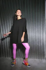 Pantalón largo de ecocuero color lila, con tiro alto, calce ajustado y botamanga irregular.