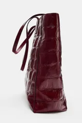 Bolso shopper de cuero bordó con estampado texturizado símil cocodrilo, diseño estructurado y doble asa fina para hombro.