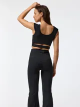 Calza flare negra con corte acampanado y cintura en forma de V.