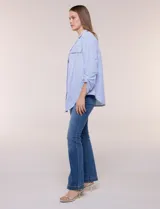 Sobrecamisa holgada de algodón liviano, con estampado de rayas verticales en tonos azul y blanco, diseño oversize, cuello solapa, mangas largas ajustables con presilla y ruedo curvo.