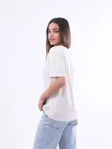 Remera blanca de manga corta con estampado frontal de una tortuga marina rodeada de corales y la frase "OCEAN LIFE".