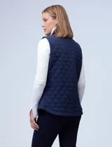 Chaleco negro capitoneado con cuello con solapa, abertura central con botones y bolsillos delanteros.