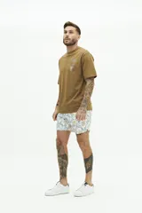 Short de baño con estampado floral en tonos azules, cintura elástica con cordón ajustable, bolsillos laterales y bolsillo trasero.