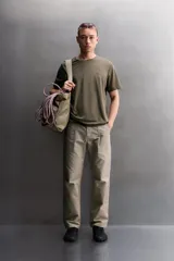 Pantalón de corte tapered fit color beige, confeccionado en tejido ligero de algodón con estructura rip stop. Cuenta con bolsillos de plastrón delanteros con acceso curvado, pinzas en las rodillas para mayor movilidad, y cierre frontal con cremallera y botón a presión.