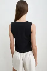 Musculosa blanca de algodón, de corte recto y escote redondo.