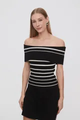Top negro de tejido de punto con escote off-shoulder y rayas horizontales blancas.