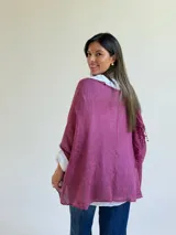 Sweater de punto magenta con diseño holgado, cuello redondo y detalles de encaje floral aplicado en el frente. Incluye una bufanda tipo choker integrada del mismo tejido.