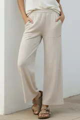 Pantalón de corte recto y tiro medio, confeccionado en tejido de algodón con textura acanalada. Presenta cintura elástica, bolsillos laterales y un calce holgado y cómodo.