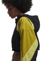 Campera deportiva de corte cropped con diseño de bloques de color en negro y verde oliva. Presenta capucha, cierre frontal, mangas raglán y puños con elástico.