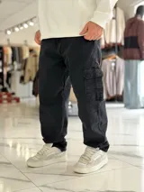 Pantalón cargo de jean azul con múltiples bolsillos en los laterales y diseño holgado.