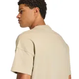 Remera de algodón color beige con cuello redondo acanalado, corte holgado y logo de Adidas bordado en el centro del pecho.